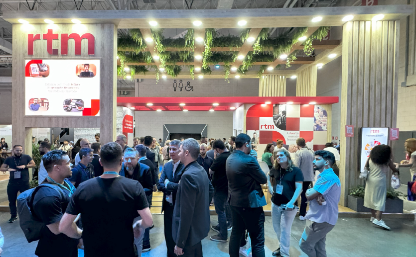 Foto do estande da RTM no Febraban Tech 2024 com movimentação de pessoas.